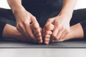 Eine Frau in der Lotus-Position umfasst ihr Füsse Eine Frau in der Lotus-Position umfasst ihr Füsse